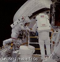Two astronauts work on space shuttle